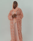 Person wearing a pink lace outfit on a light gray background