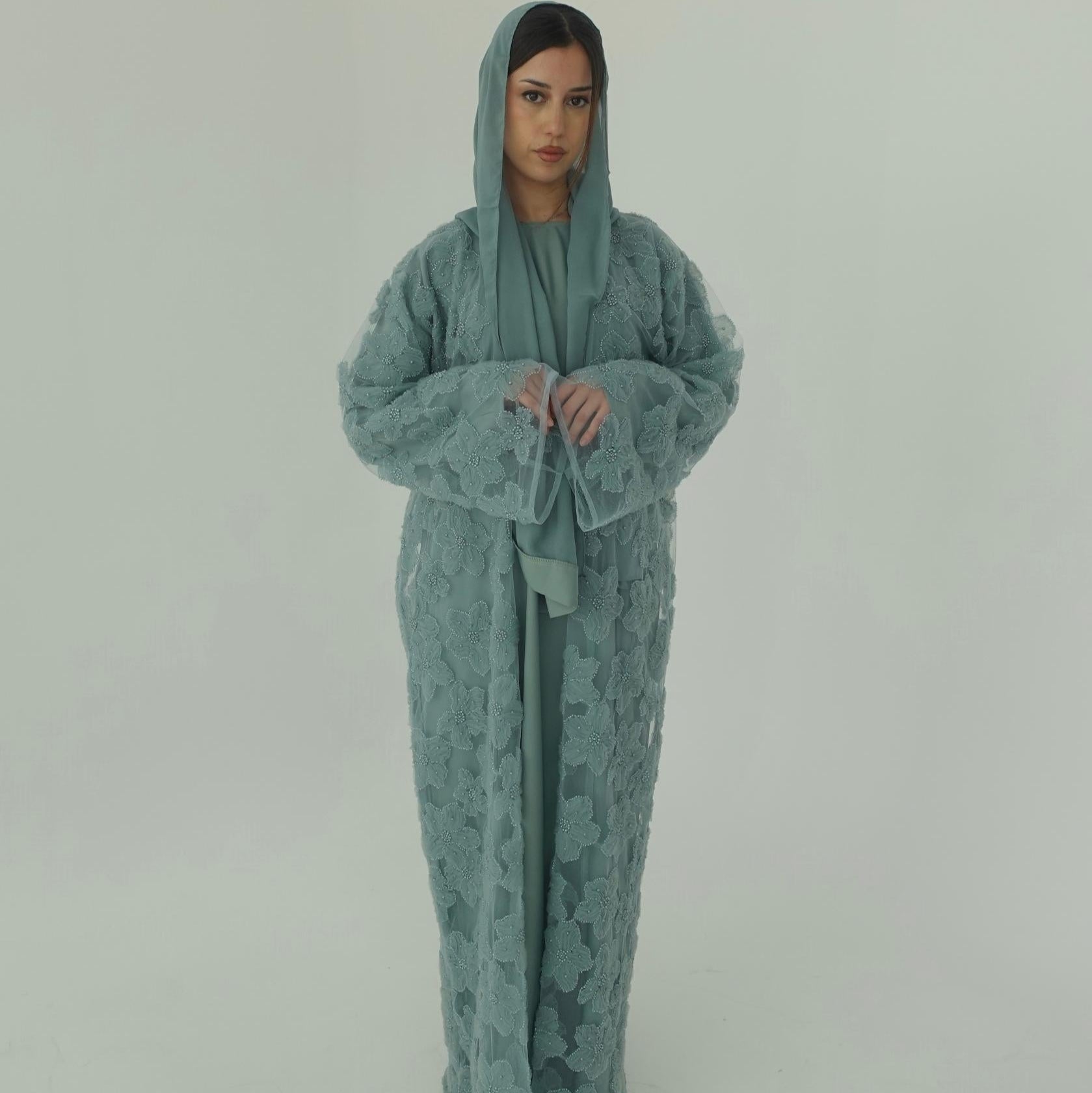Person wearing a green hooded outfit on a plain background
