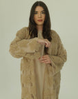 Woman wearing a beige textured robe against a plain background