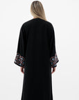 Black Liana Abaya with hand-sewn silver beads in a leaf and embroidery design pattern on the arms. Light pink, blue, and purple threads add color to the embroidery. Comes with a matching black hijab and popper buttons for closure.