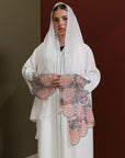 White abaya with silver beadwork and pink and brown embroidery on the sleeves. Made from crepe material with popper buttons, available in sizes 50-60, and includes a matching hijab.