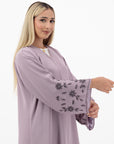Neha Abaya available in White and Pastel Purple, with beaded floral and leafy designs on the sleeves. Made from crepe fabric with popper buttons, available in sizes 50-60. Includes a matching hijab.