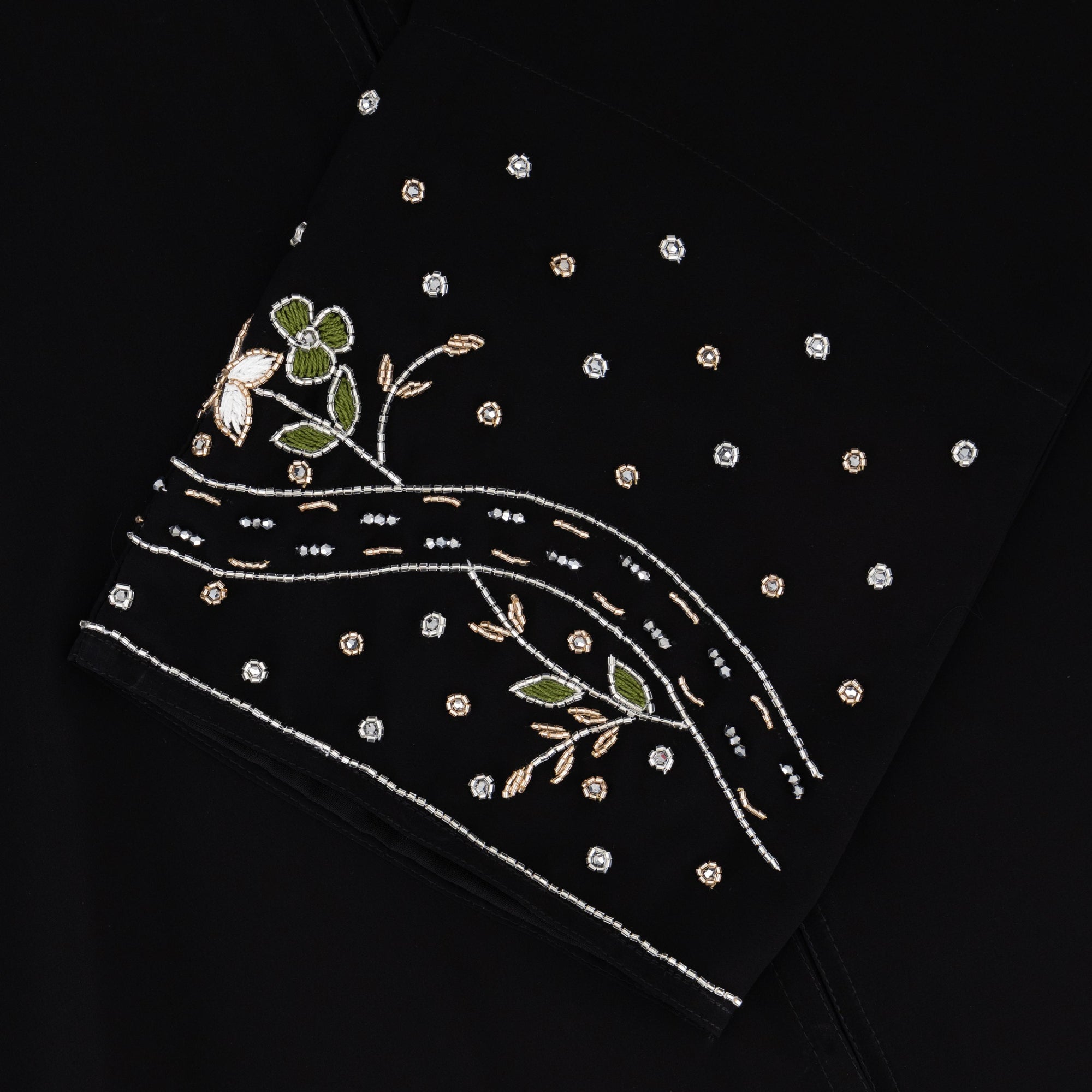 Reema Abaya available in Black, Vanilla, and Chocolate Brown with golden and silver beaded sleeves in a floral and leafy design. Made from crepe fabric with popper buttons, available in sizes 50-60. Includes a matching hijab.