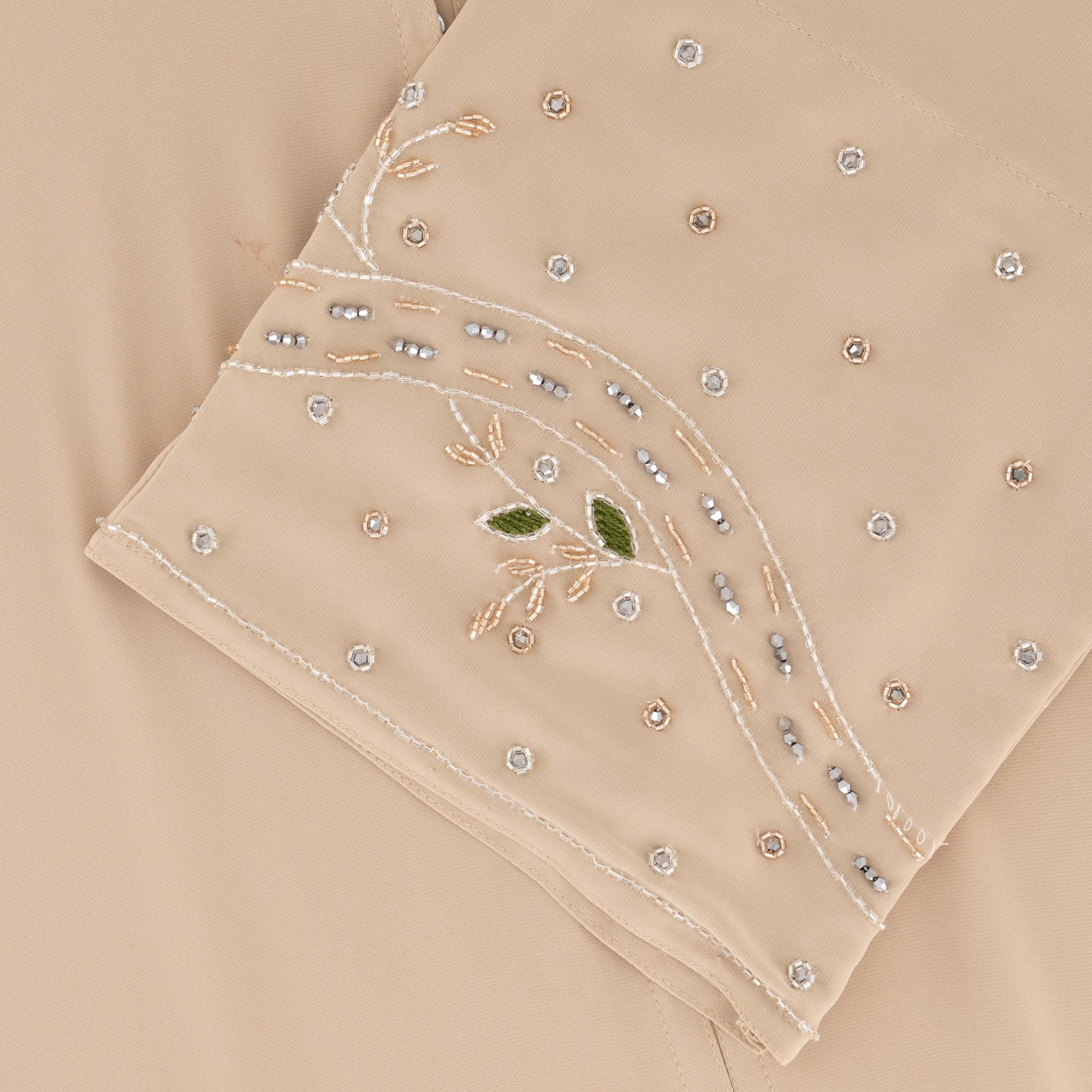 Reema Abaya available in Black, Vanilla, and Chocolate Brown with golden and silver beaded sleeves in a floral and leafy design. Made from crepe fabric with popper buttons, available in sizes 50-60. Includes a matching hijab.