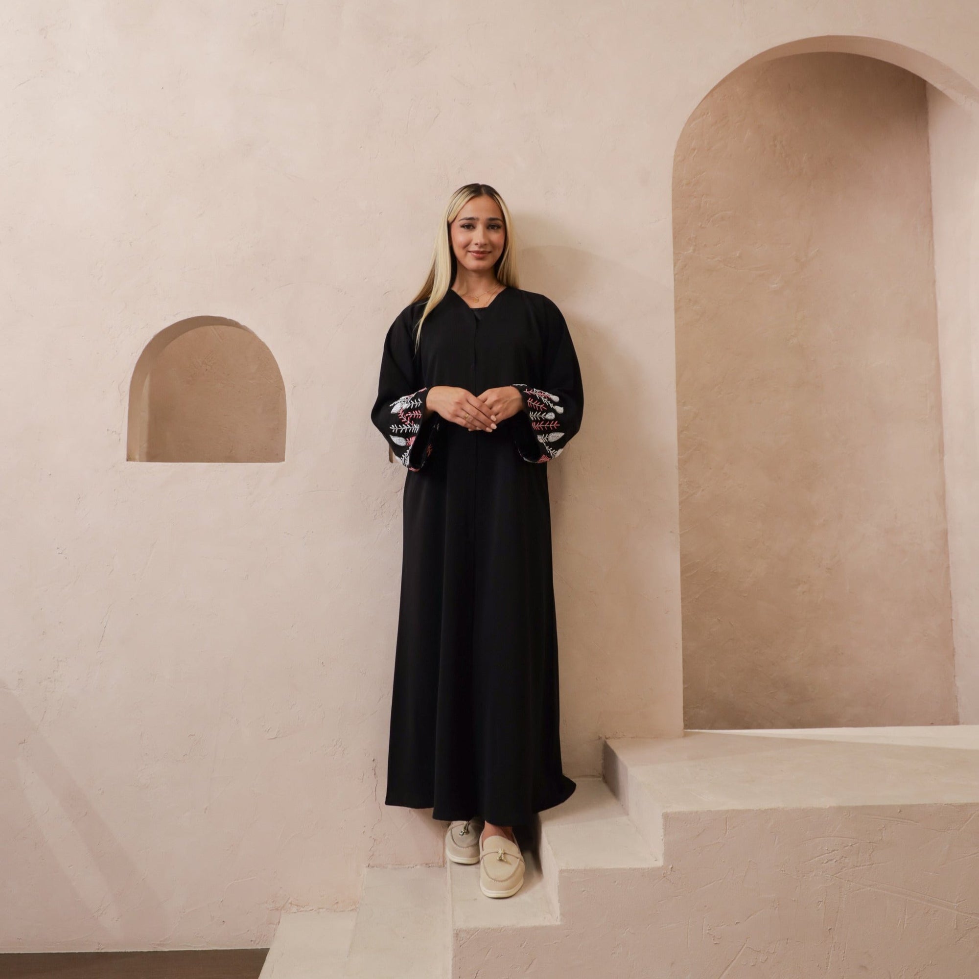 Black abaya with silver and white beadwork, pink and white leaf embroidery, Zoom fabric, popper buttons, matching black hijab, available in sizes 50-60.