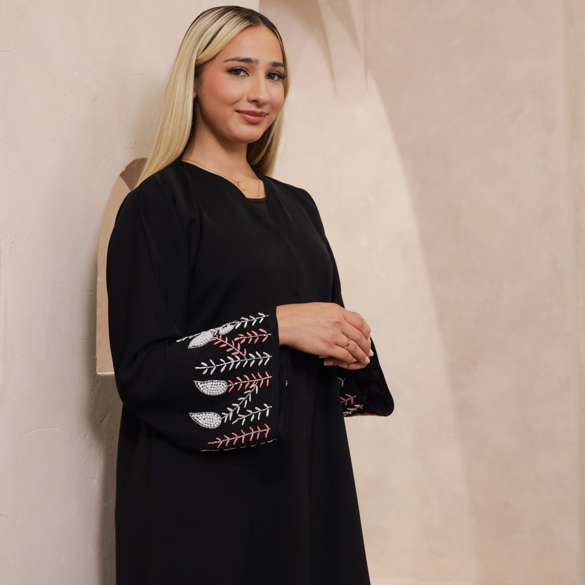 Black abaya with silver and white beadwork, pink and white leaf embroidery, Zoom fabric, popper buttons, matching black hijab, available in sizes 50-60.