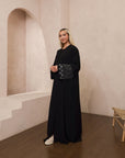 Amelia open abaya with detailed sleeves, available in sizes 52-58. Crafted from soft, flowing fabric, it offers an elegant, modest look for formal occasions, Eid celebrations, and professional events. Comfortable fit and easy-care, hand wash only.