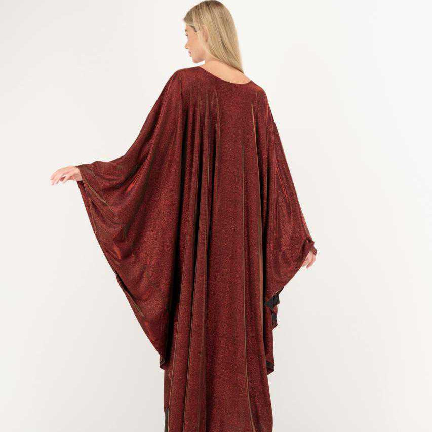 Woman wearing a burgundy long dress with a flowing design on a white background