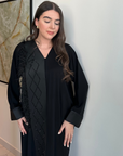 A luxurious black Nidha-lined open abaya featuring intricate black beaded and furry detailing, designed for elegance and comfort. Includes convenient popper buttons and a complimentary hijab for a polished look. Perfect for any occasion with a soft, breathable, and flowy fit.