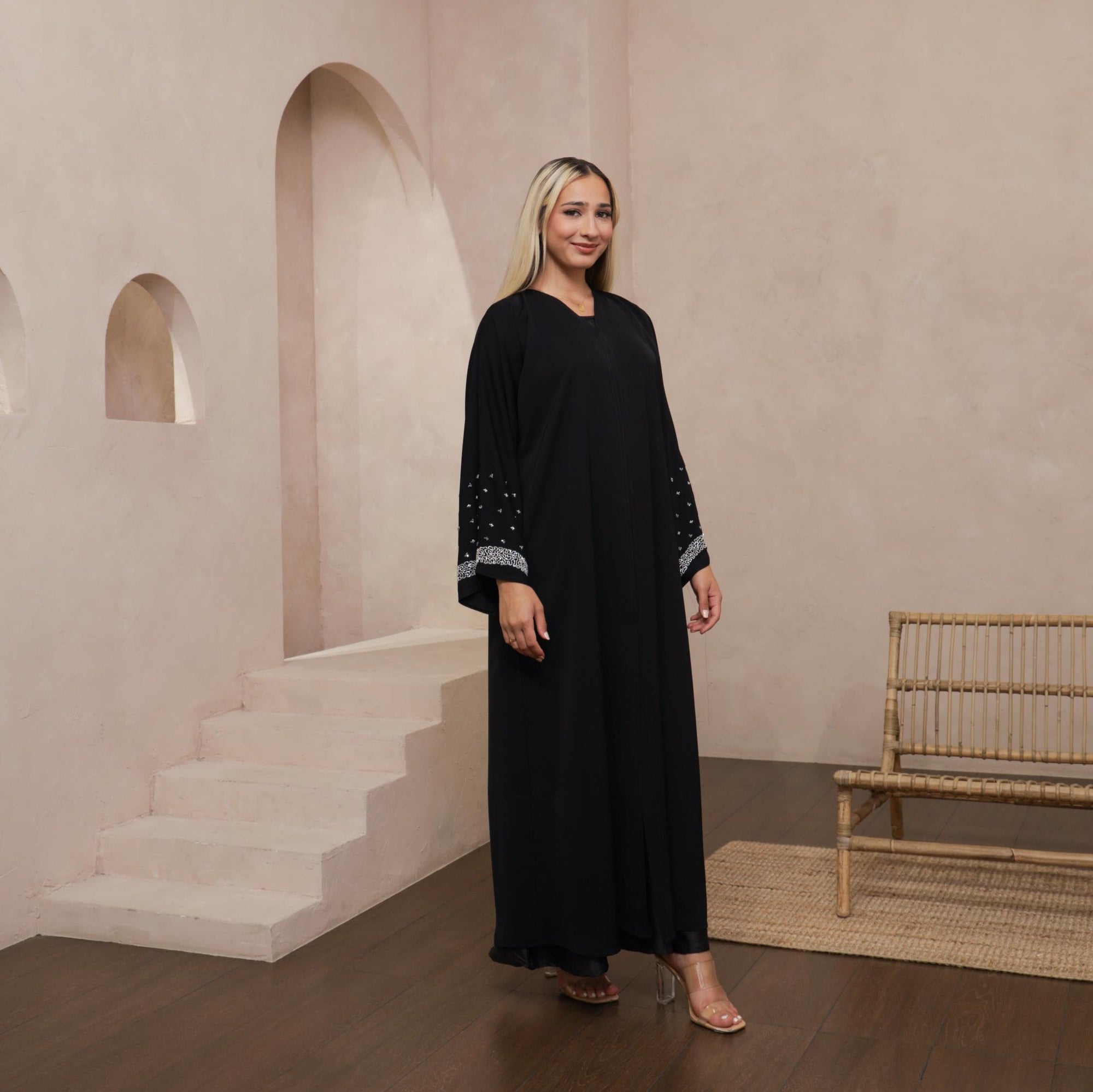 Black Lylah Abaya with hand-sewn silver beads detailing along the sleeves. Includes a matching black hijab and features popper buttons for closure.