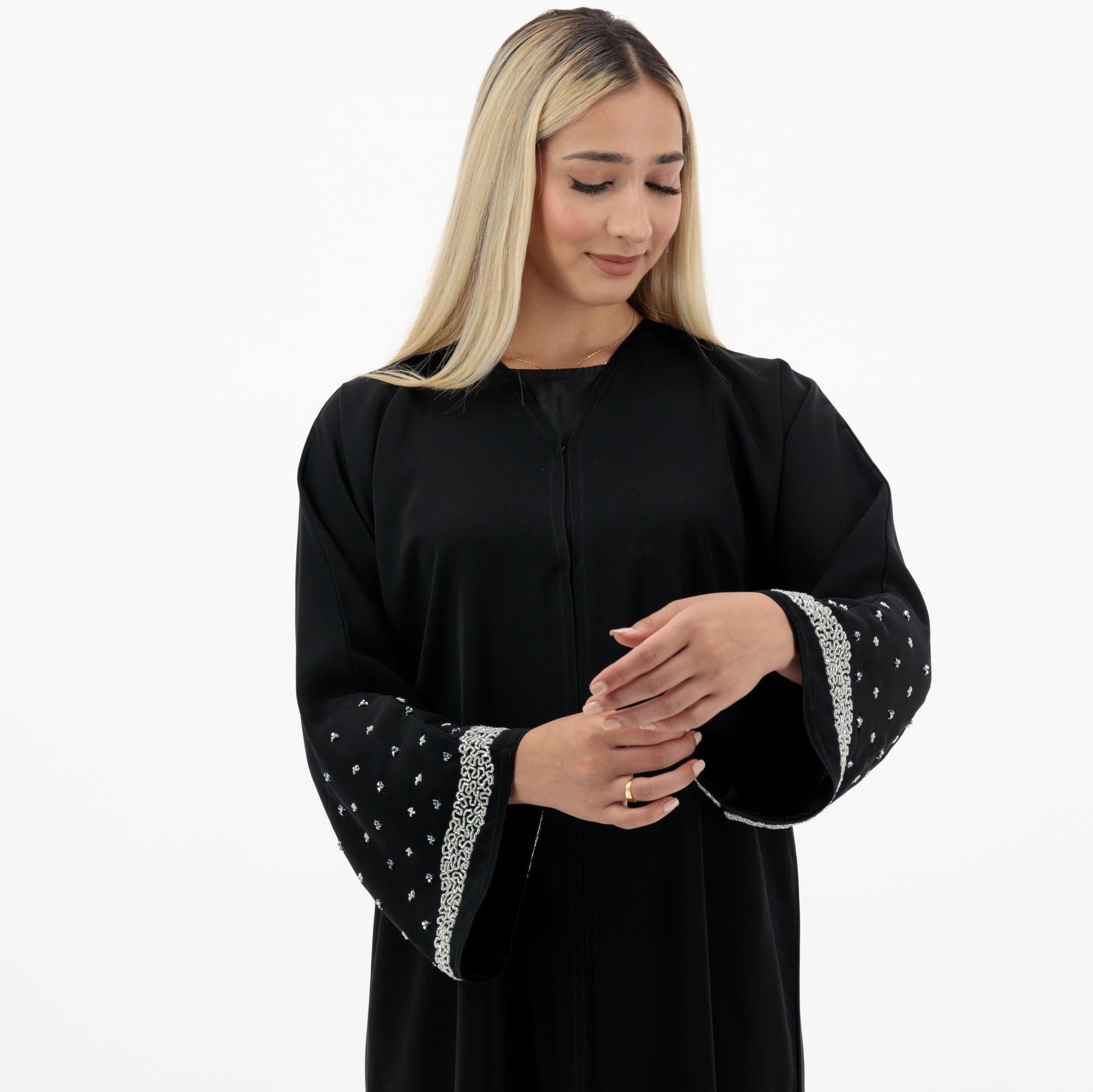 Black Lylah Abaya with hand-sewn silver beads detailing along the sleeves. Includes a matching black hijab and features popper buttons for closure.