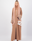 The Sapna Abaya features silver beaded sleeves, popper buttons, and a white line detail. Available in black, beige, brown, and white, made from Zoom fabric in sizes 50-60. Includes a matching hijab.