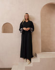 Black abaya with silver and white beadwork, pink and white leaf embroidery, Zoom fabric, popper buttons, matching black hijab, available in sizes 50-60.