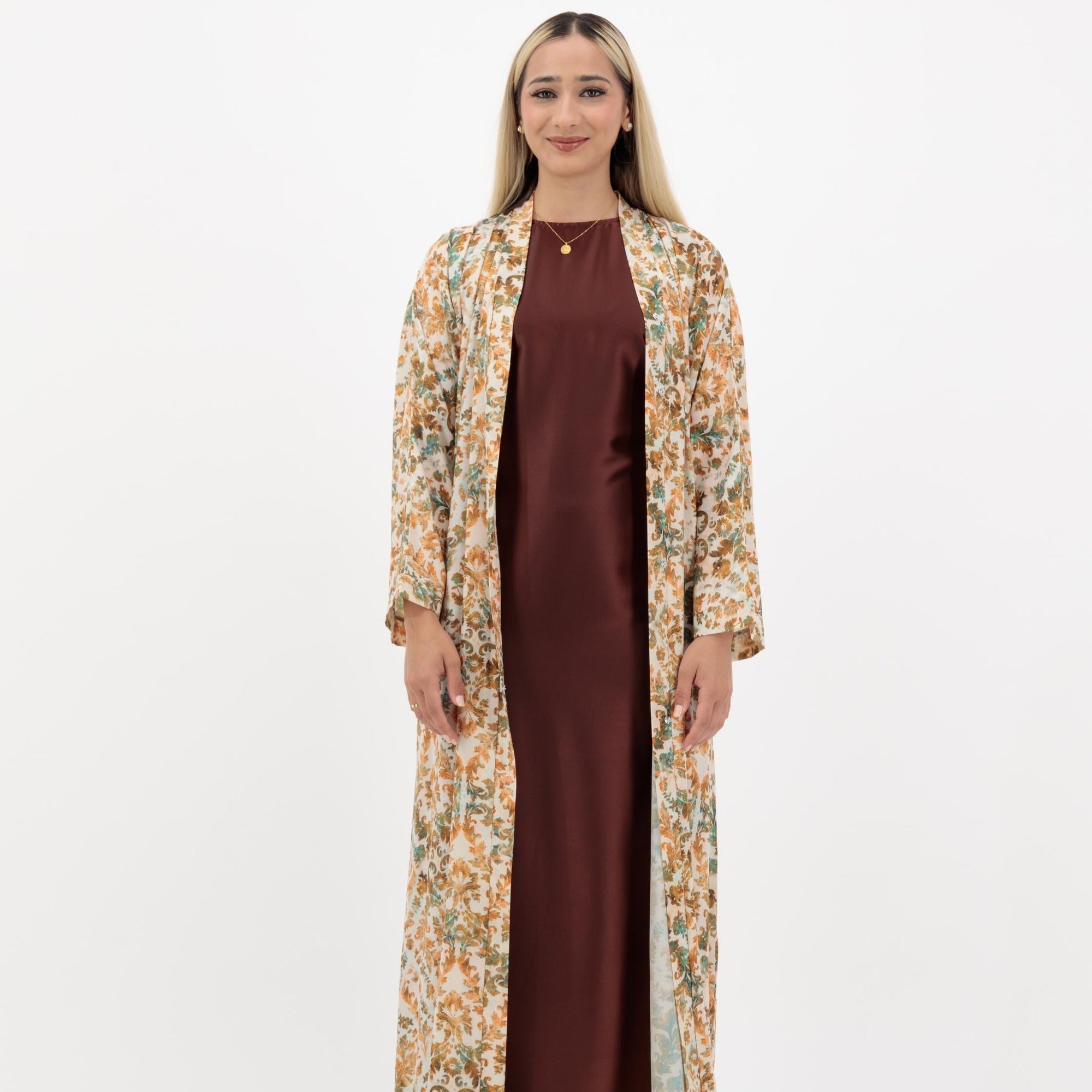 Zinnia Abaya available in three prints: Cloud white with dull orange, cloud white with chocolate brown, and cloud white with terra cotta, an open abaya with popper buttons, made from crepe material, available in sizes 50-60.